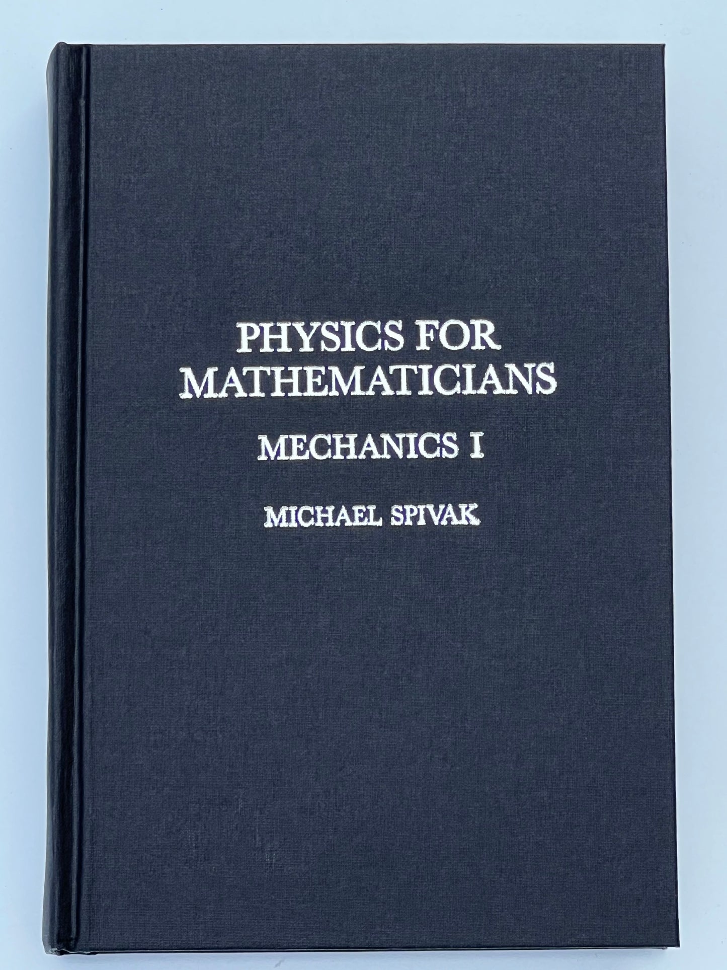Front cover of the book titled 'Physics for Mathematicians: Mechanics I' by Michael Spivak, featuring a dark cover with silver text.