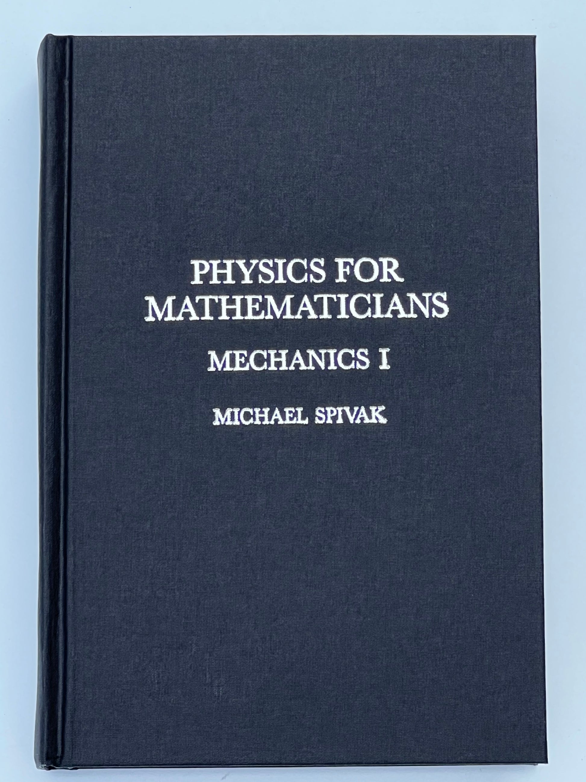 Front cover of the book titled 'Physics for Mathematicians: Mechanics I' by Michael Spivak, featuring a dark cover with silver text.
