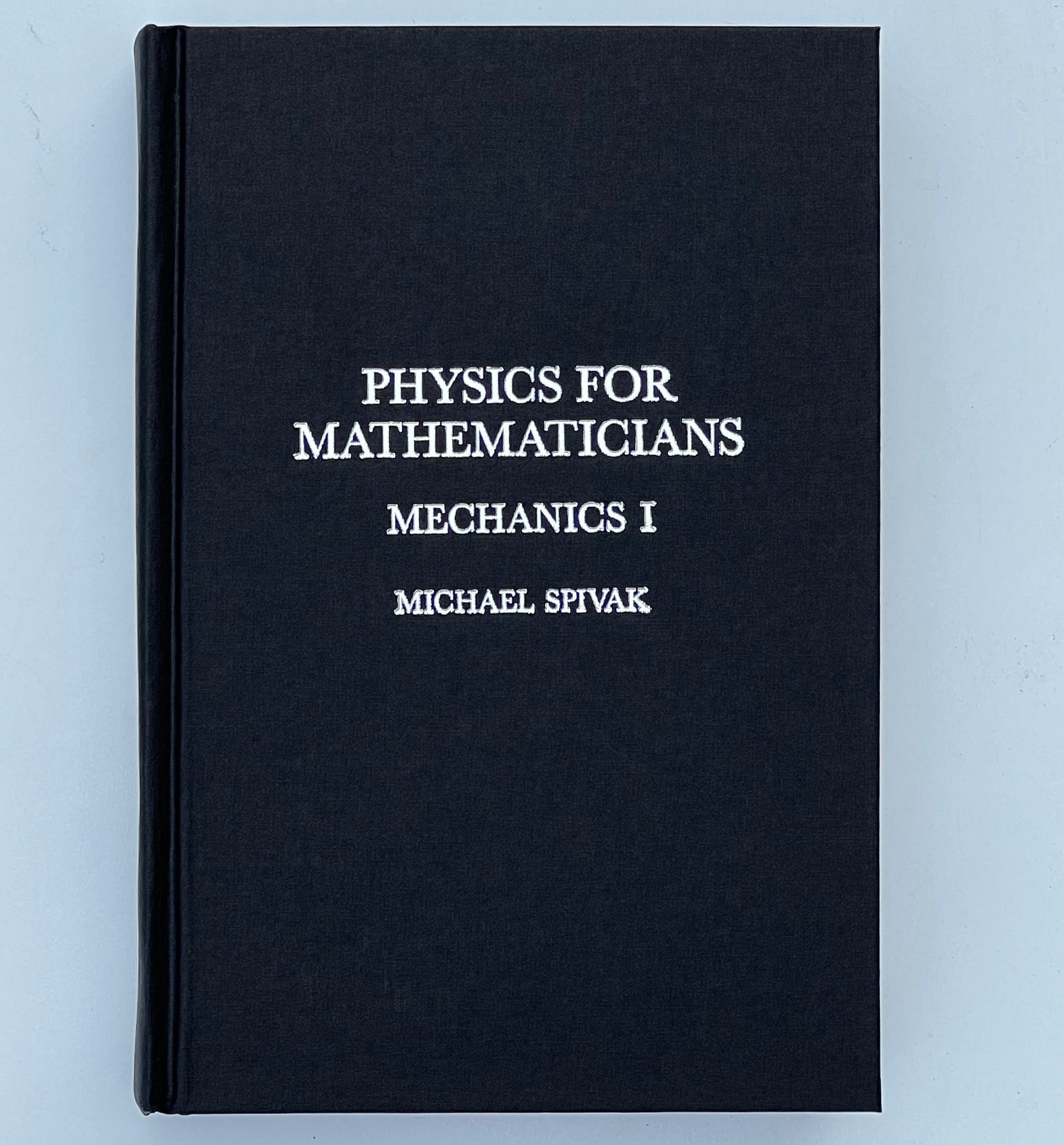 Front cover of the book titled 'Physics for Mathematicians: Mechanics I' by Michael Spivak, featuring a black cover with silver text